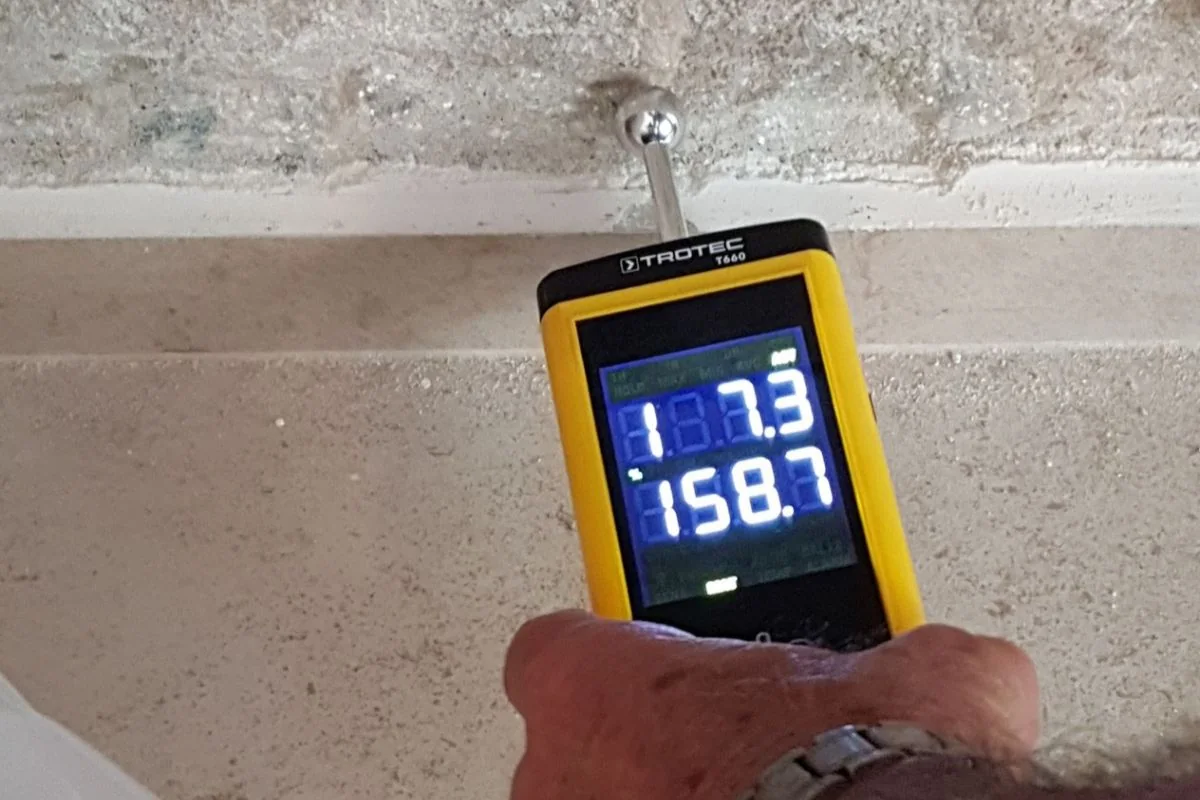 Moisture meter checking a baseboard after water damage